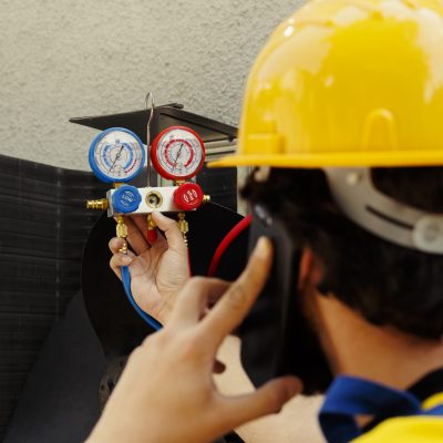 Expert repairman speaking over the phone with business owner, reporting found freon leaks leading to worse cooling efficiency after meticulous investigation during outside air conditioner checkup